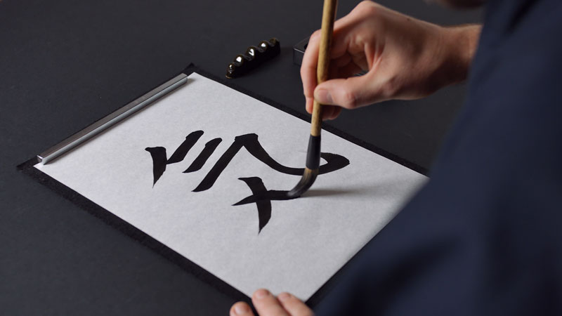Robert Bąk kaligrafuje japoński znak Ki - energia